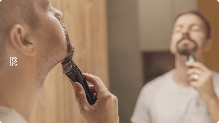 Billede af mand, der barberer sig med en barbermaskine.