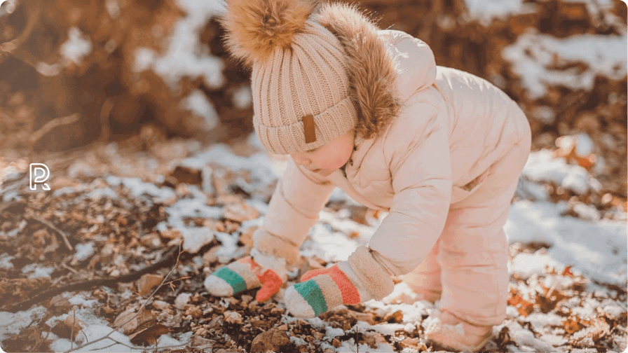 Billede af barn i flyverdragt – leg med sne i skovbunden