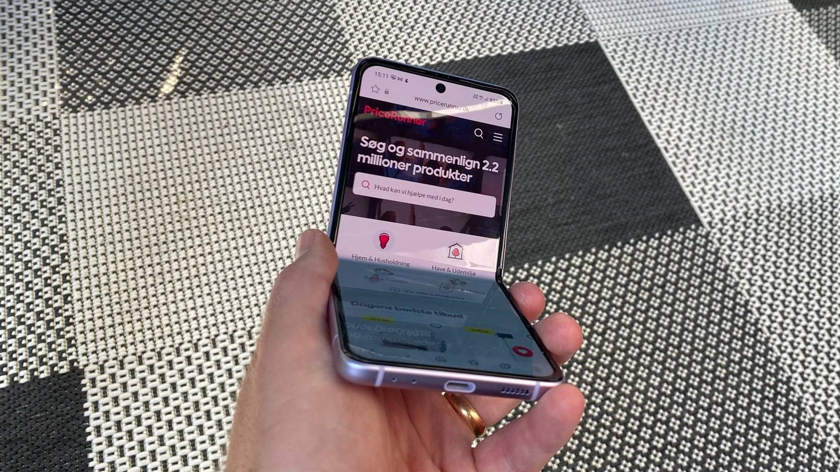 Billede fra test af mobiltelefon Samsung Galaxy Z Flip3 - halvt sammenfoldet med PriceRunner.dk på skærmen