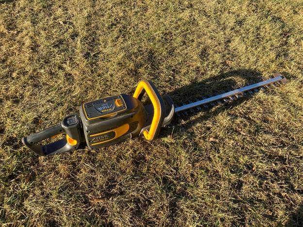 Billede fra test af hækkeklipper Stiga SHT 700 AE liggende på græsset