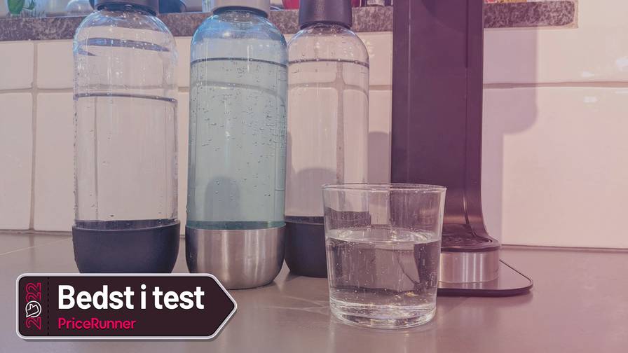 Test af sodavandsmaskiner - et glas med danskvand foran flasker med danskvand og en sodavandsmaskine